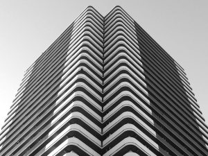 Black and white photo of a symmetrical modern building in urban Japan.